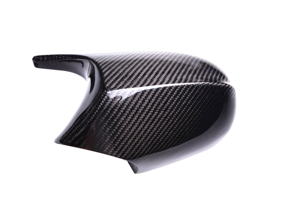 A black carbon fiber motorcycle mirror cover reflecting light, showcasing a glossy finish and textured pattern, isolated on a white background.