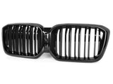 A shiny black car grill with a double kidney shape features vertical slats, positioned against a plain white background.