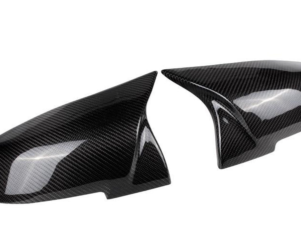Two carbon fiber car mirror caps are displayed side by side on a plain white background, showcasing their glossy, textured finish and sleek aerodynamic design.