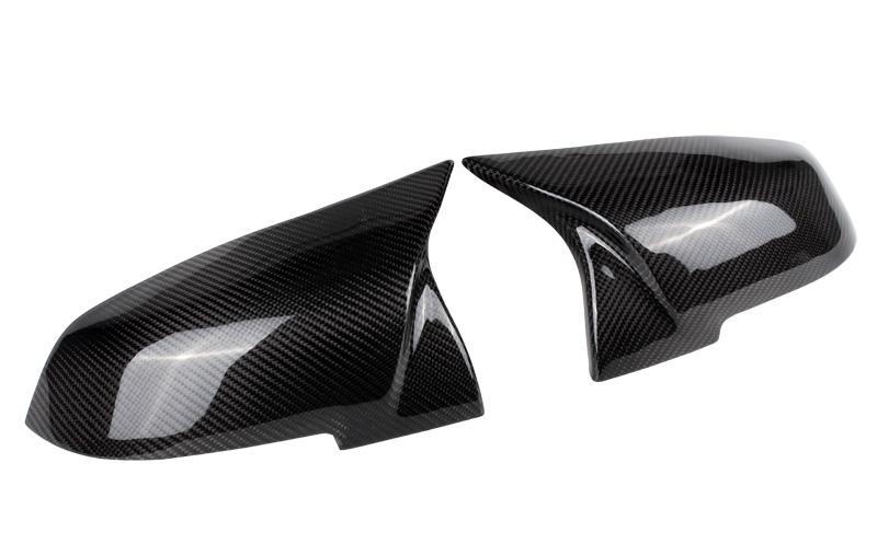 Two carbon fiber car mirror caps are displayed side by side on a plain white background, showcasing their glossy, textured finish and sleek aerodynamic design.