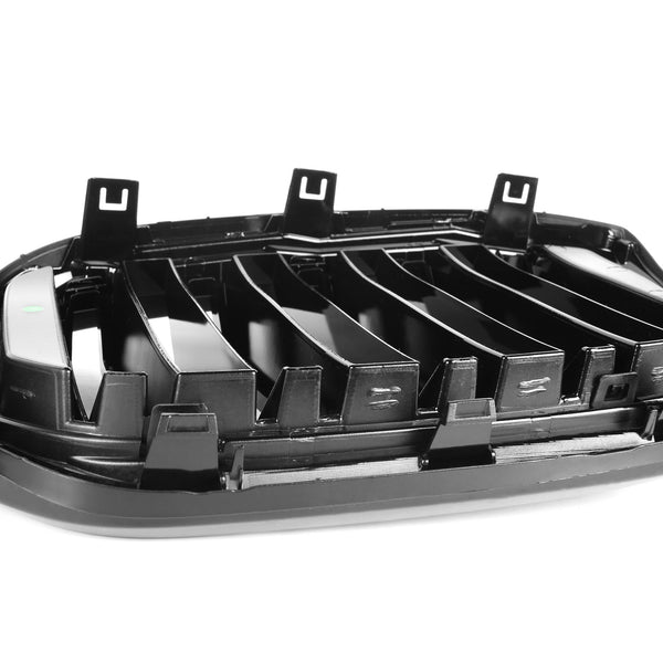 A black plastic car grill assembly with multiple vertical slats and securing clips is resting on a plain white background.