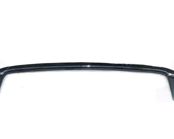 A black metallic car spoiler curves upward, flanked by two triangular end-pieces. It rests against a plain white background, casting faint shadows.