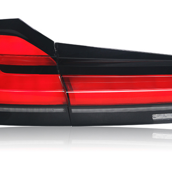 A red and black car taillight is positioned against a white background, highlighting its sleek, angular design with multiple segments and reflective surfaces.
