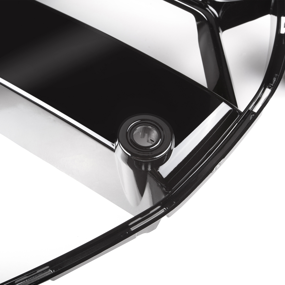 A black, glossy plastic cover with a circular keyhole, set on a white background, possibly part of a car accessory or appliance.