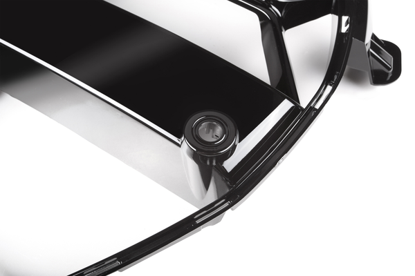 A black, glossy plastic cover with a circular keyhole, set on a white background, possibly part of a car accessory or appliance.