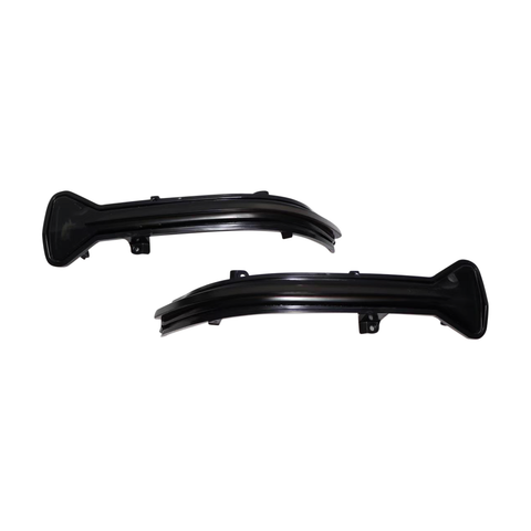 Two curved black plastic car parts lay side by side on a white background, each featuring a broad base and a tapered end, likely designed for mounting on a vehicle.
