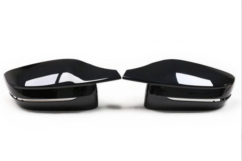 Two glossy black car side mirrors facing each other, set against a plain white background. They have a sleek, aerodynamic design with a subtle chrome accent beneath.