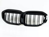 A black dual-section car grille, featuring vertical slats, is resting on a white background.