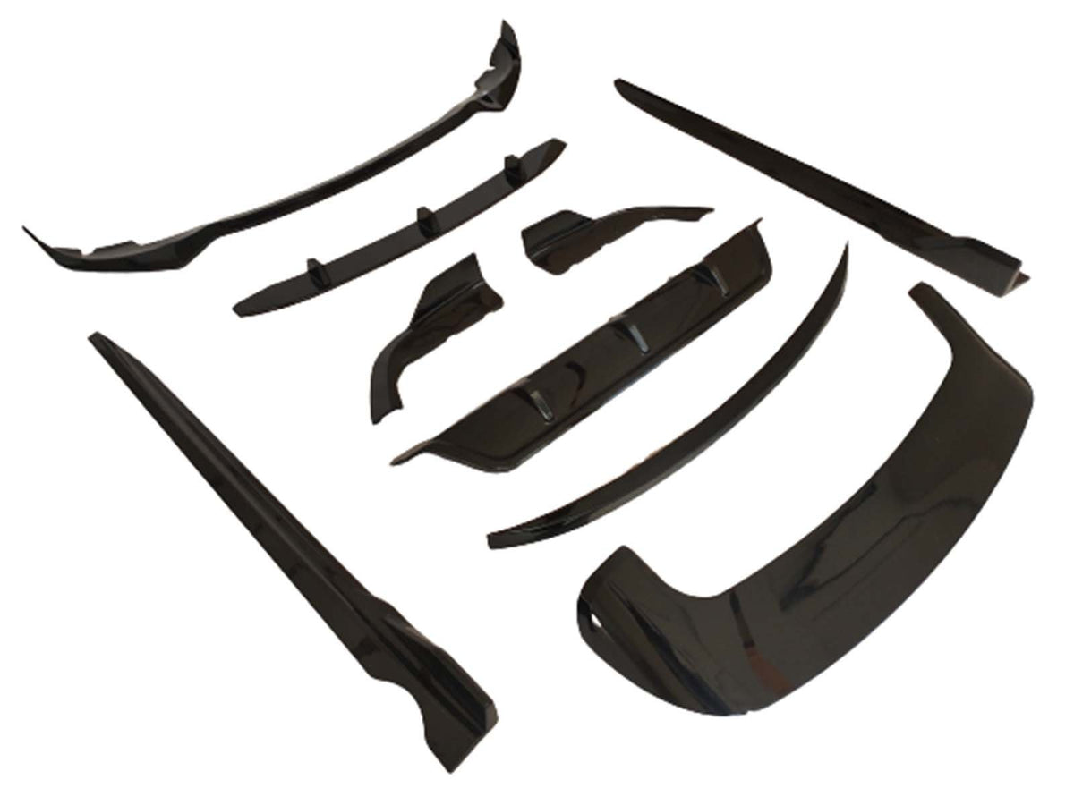 Black automobile body kit components are arranged on a white background. The kit includes various aerodynamic pieces like a front lip and side skirts, designed for vehicle exterior enhancements.