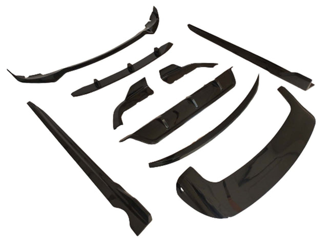 Black automobile body kit components are arranged on a white background. The kit includes various aerodynamic pieces like a front lip and side skirts, designed for vehicle exterior enhancements.