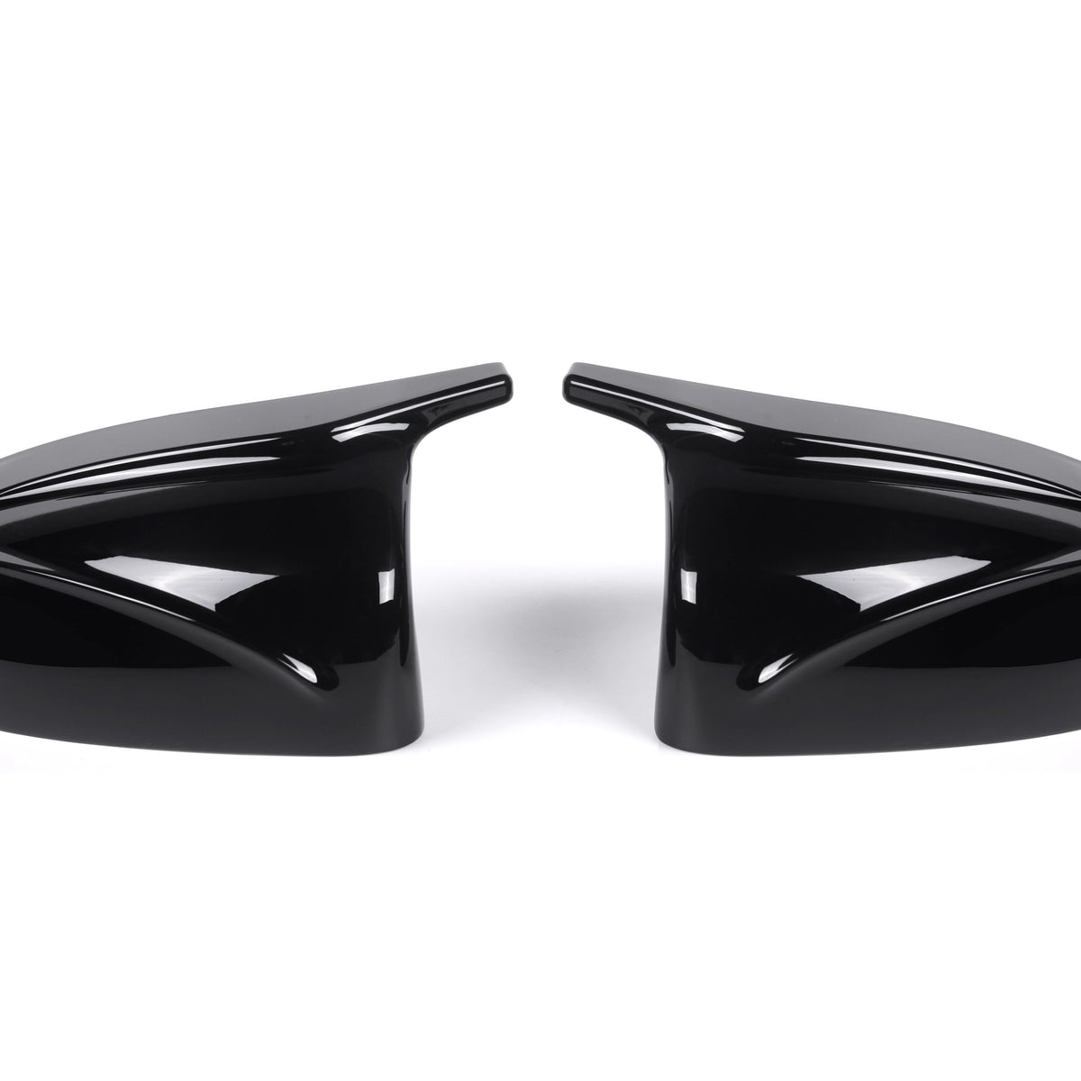 Two sleek black car side mirror covers face each other, reflecting light. They rest on a plain white background, showcasing their glossy finish and aerodynamic design.