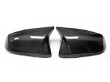 Two glossy carbon fiber car mirror covers, facing each other, are placed on a white background, highlighting their sleek and modern design.
