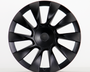 A black, multi-spoke car wheel cover with a subtle central logo sits upright against a plain white background, showcasing its sleek, aerodynamic design.