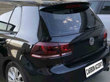 A black car is parked beside a white car in a lot. The rear view shows a Volkswagen logo and text reading 