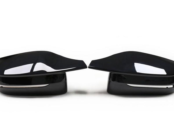 Two sleek, black car side mirrors face each other, reflecting light. They are placed on a plain white background, emphasizing their glossy surface and modern design.