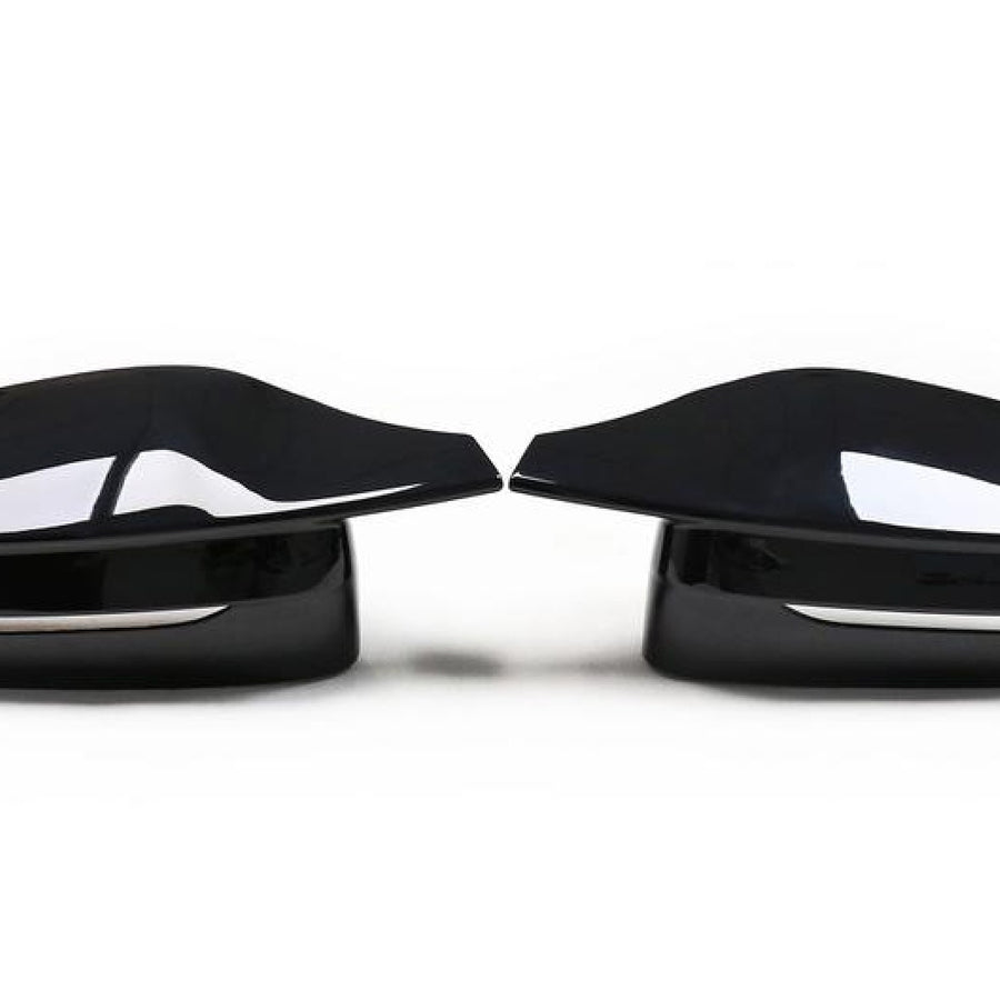 Two sleek, black car side mirrors face each other, reflecting light. They are placed on a plain white background, emphasizing their glossy surface and modern design.