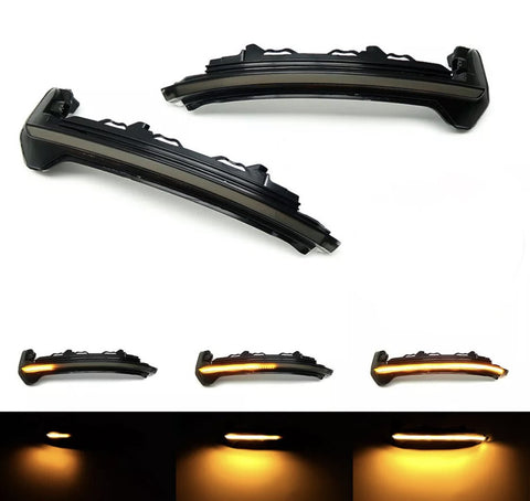 Two black car side mirrors with integrated LED turn signals, displayed on a white background. The lower images show the LED lights illuminated in amber, demonstrating various lighting effects.