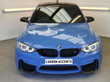 A blue BMW sports car, parked in a well-lit showroom, features the text 