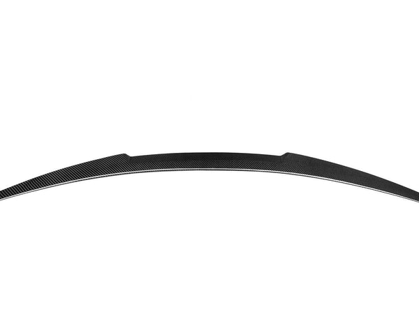 Curved carbon fiber car spoiler resting in a plain white background. The spoiler features a sleek, streamlined design and symmetrical tapering at both ends.