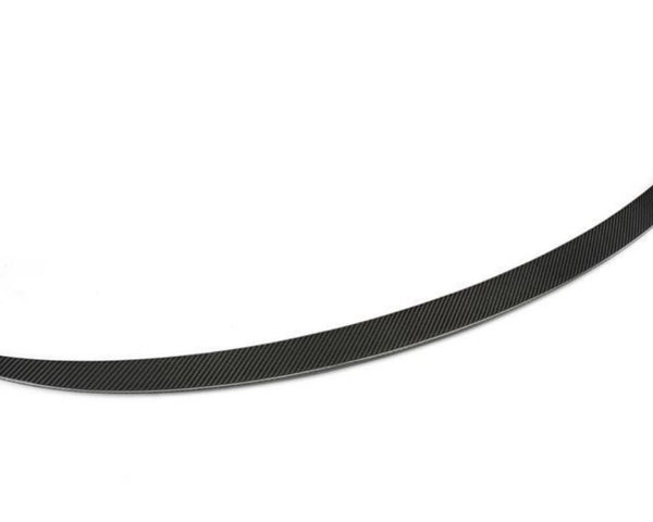 A sleek, curved black carbon fiber spoiler blade rests on a white background, showcasing a finely textured surface with diagonal patterns, designed to enhance vehicle aerodynamics.