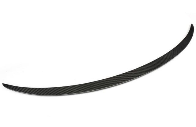 A sleek, curved black carbon fiber spoiler blade rests on a white background, showcasing a finely textured surface with diagonal patterns, designed to enhance vehicle aerodynamics.