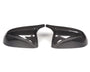 Two carbon fiber side mirror covers face each other, showing a glossy finish and distinct weave pattern, placed on a white background.