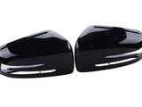 Two identical black plastic car side mirror covers, positioned symmetrically, face each other. They have a glossy finish and are designed to fit over existing mirrors, set against a plain white background.