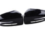 Two identical black plastic car side mirror covers, positioned symmetrically, face each other. They have a glossy finish and are designed to fit over existing mirrors, set against a plain white background.
