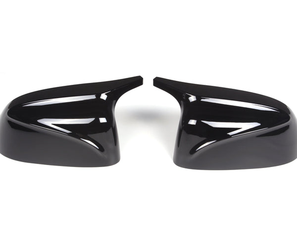 Two glossy black side mirror covers positioned symmetrically, facing each other against a white background, designed for automotive use.