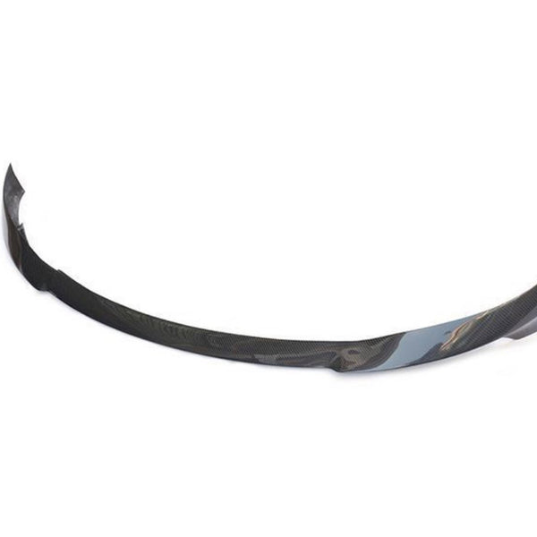 Curved carbon fiber car bumper lip rests on a white background, showcasing its sleek, aerodynamic design intended for vehicle front-end attachment.