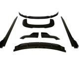 Black car body kit pieces arranged on a white background, including a bumper lip, side skirts, and diffuser parts, all presented symmetrically and evenly spaced.