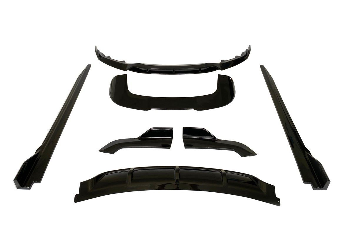 Black car body kit pieces arranged on a white background, including a bumper lip, side skirts, and diffuser parts, all presented symmetrically and evenly spaced.
