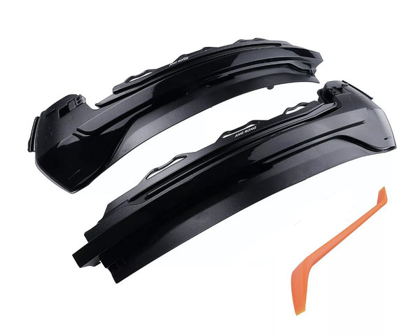 Two black automotive light covers, labeled "ANG RONG," rest near an orange plastic tool on a white background.