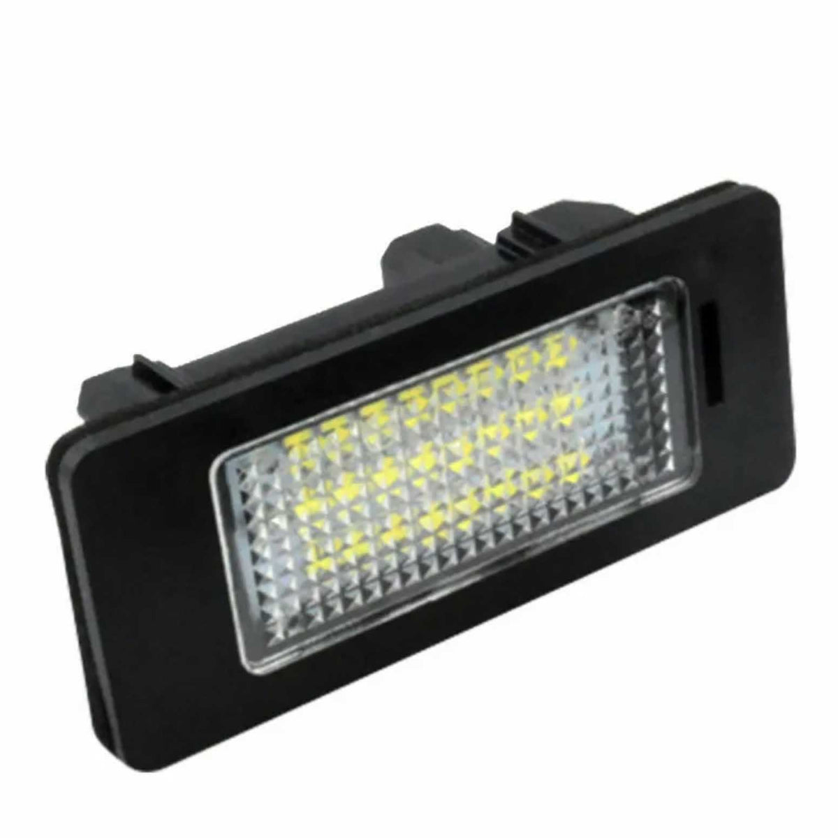 A rectangular LED light module with a textured lens emits light from multiple small diodes, encased in a black plastic frame, typically used for vehicle license plate illumination.