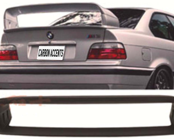 A silver car's rear with a large spoiler and "CARBON ACCENTS" text on the license plate. Below, a detached black car part is displayed in front of a white backdrop.