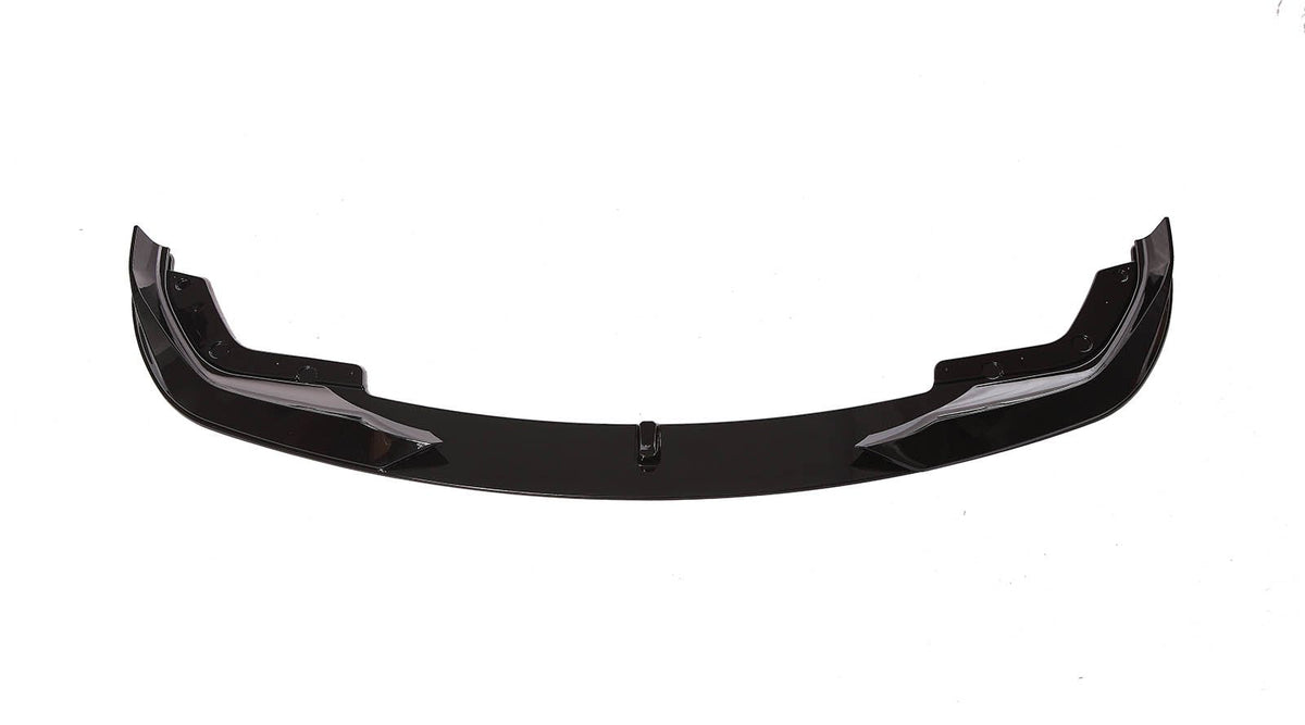 A sleek, black car front lip spoiler, resting on a white background, showcasing its aerodynamic shape with curved ends and bolt fixtures.