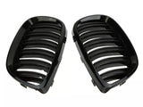 Two black, glossy car grilles with parallel slats are positioned side by side against a plain, white background, likely intended for vehicle front-end installation.