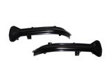 Two sleek, black plastic car parts with mounting brackets are displayed on a plain white background, suggesting components for an automotive lighting system.