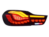 A car tail light emits bright red and amber lights, featuring modern, segmented design elements against a white background.