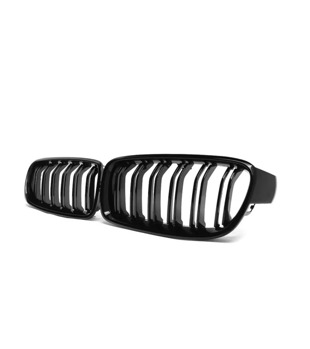 A black kidney grille with vertical slats, resting against a white background. It appears to be a component for a vehicle, possibly the front grille of a car.