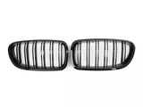 Two black, oval car grilles with vertical slats are positioned side by side against a plain white background.