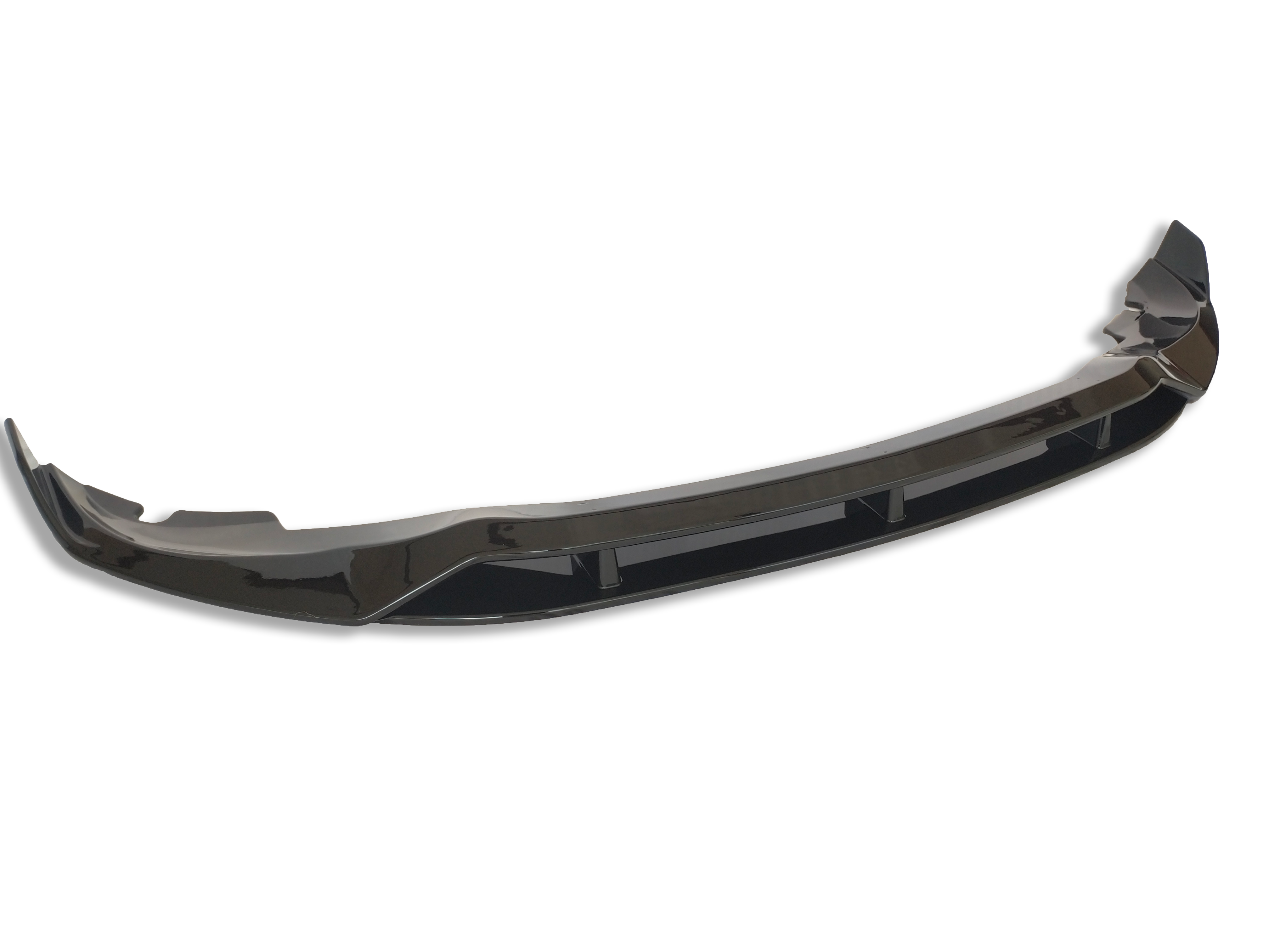 A glossy black car bumper lip sits isolated against a white background, showcasing its curved aerodynamic design and reflective surface.