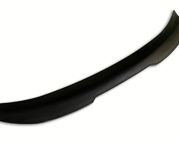 A curved carbon fiber car spoiler rests against a plain white background, showcasing a sleek aerodynamic design with a textured surface pattern.