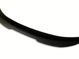 A black carbon fiber car spoiler with a subtle curvature sits against a plain white background, highlighting its aerodynamic design.