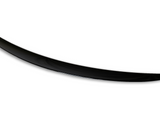 A sleek, elongated black object, resembling a boomerang or crescent shape, lies against a plain white background, its surface smooth and polished.