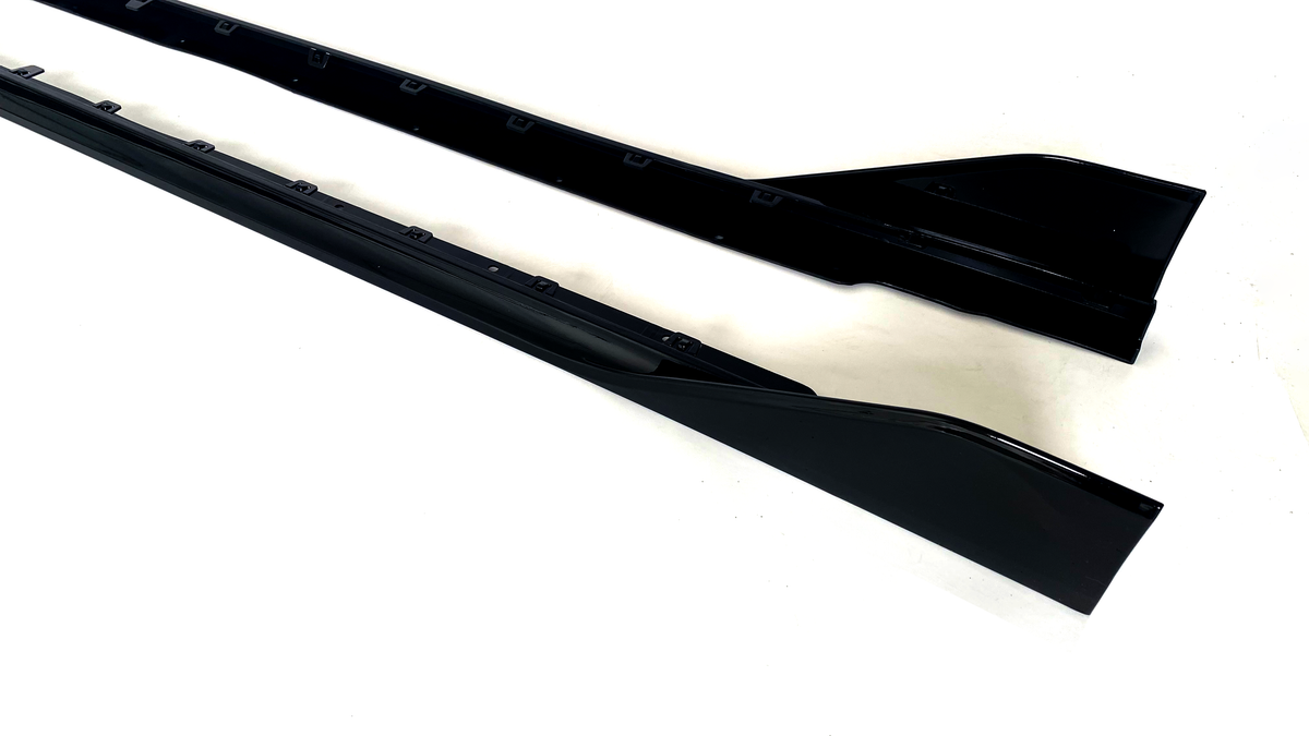 Two black side skirts, sleek and elongated, are positioned parallel on a plain white background.