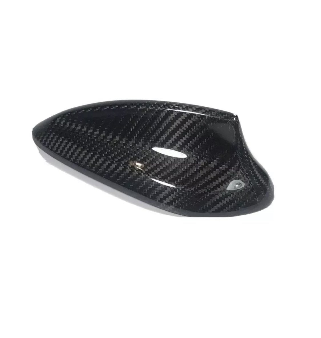 Carbon fiber car side mirror cover, sleek and glossy, lies on a white background, showcasing its weave pattern and aerodynamic shape.