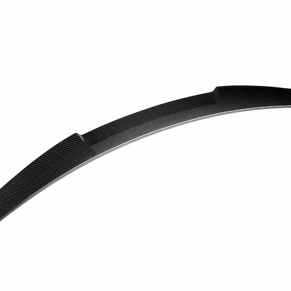 Curved black carbon fiber car spoiler lies against a plain white background, emphasizing its sleek, aerodynamic design and textured surface without any additional elements or text.