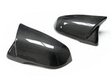 Two carbon fiber car mirror covers rest on a white background, displaying a sleek, shiny surface with a distinctive weave pattern, designed for automotive use.