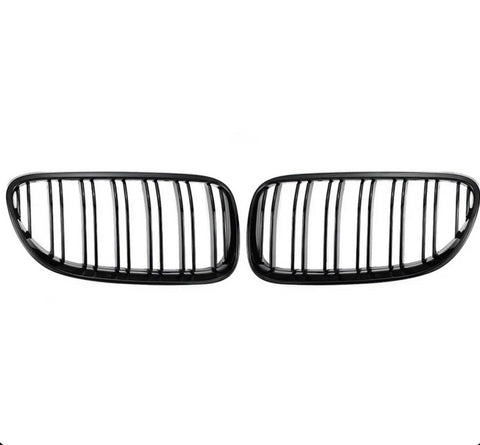 Two black kidney-shaped car grilles with vertical slats are positioned side by side against a plain white background.